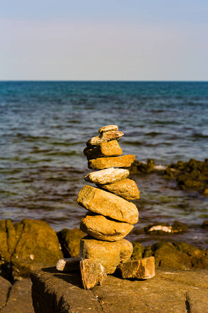 Pedra de pilha de equilíbrio sobre o horizonte da costa do mar, fundo zen abstrato
 - Foto, Imagem