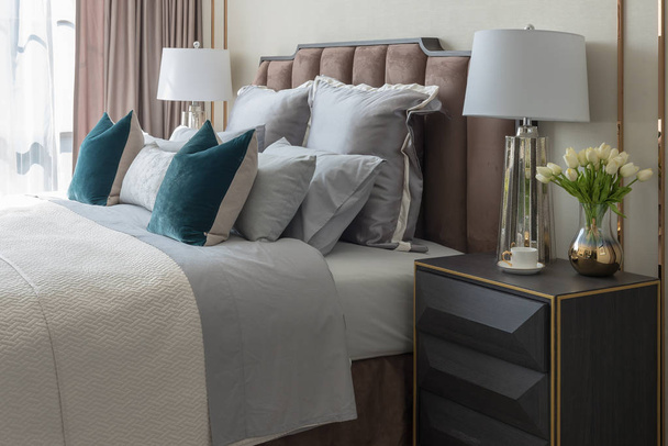 acogedor dormitorio de estilo clásico con conjunto de almohadas y lámpara en el lado de la mesa, concepto de diseño de interiores
 - Foto, imagen