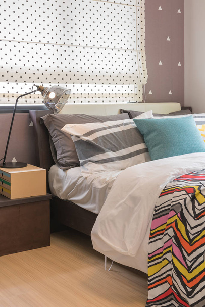 cama individual en dormitorio moderno con almohadas de colores, concepto de diseño de decoración de interiores
 - Foto, imagen