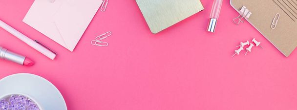 Creative top view flat lay of workspace desk styled design office supplies and cup of tea with copy space on a bright pink color paper long wide banner. Template for feminine blog social media - Zdjęcie, obraz