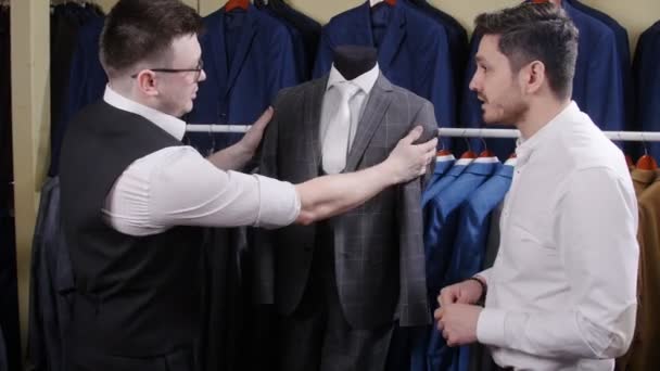 Ein Mann kauft einen Anzug in einem Geschäft - Filmmaterial, Video