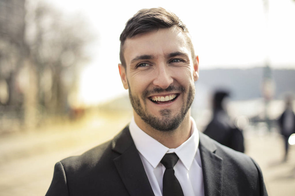 Young businessman smiling confidently outdoor. - Fotoğraf, Görsel