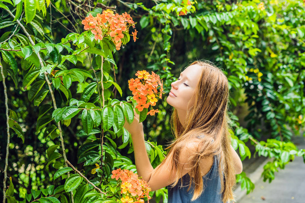 Young woman enjoying a beautiful blooming garden at daytime - Foto, Imagen