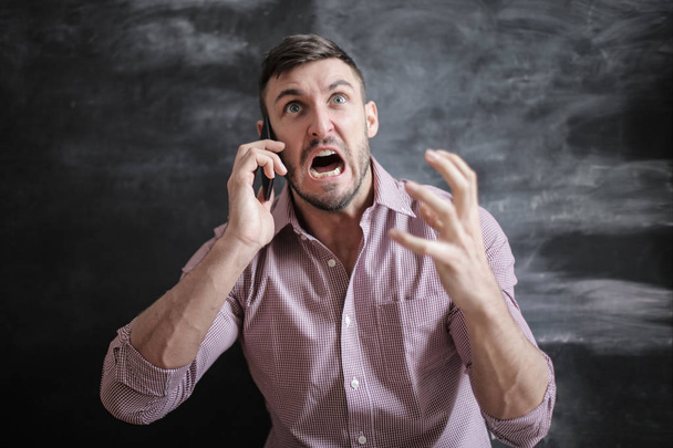 Angry young man yelling on the phone. - Valokuva, kuva