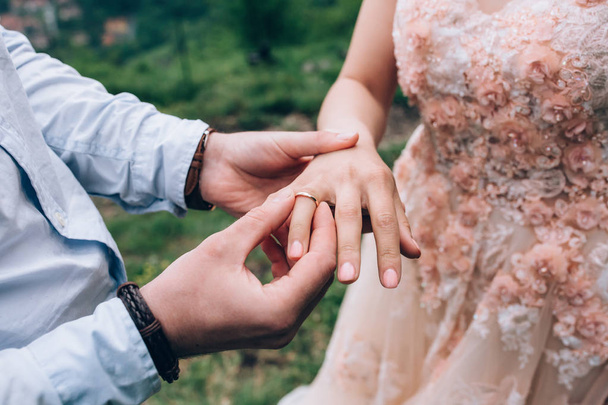 The bride and groom dress each other's wedding rings. - Φωτογραφία, εικόνα