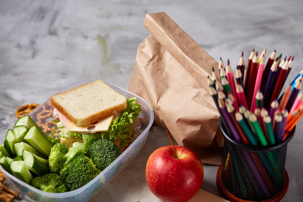 School or picnic lunch box with sandwich and various colorful vegetables and fruits on wooden background, close up. - Φωτογραφία, εικόνα