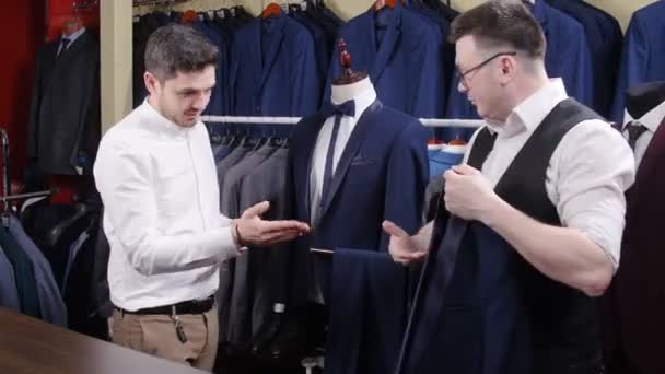 Ένας άνδρας αγοράζει ένα κοστούμι σε ένα κατάστημα - Πλάνα, βίντεο
