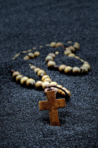 wooden rosary in black sand close - Photo, Image