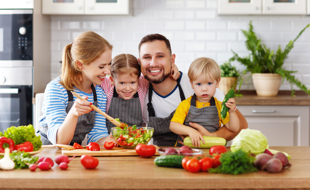 紅で野菜サラダを準備する子と幸せな家庭 - 写真・画像