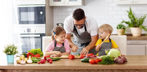   father with children preparing vegetable salad  - Photo, Image