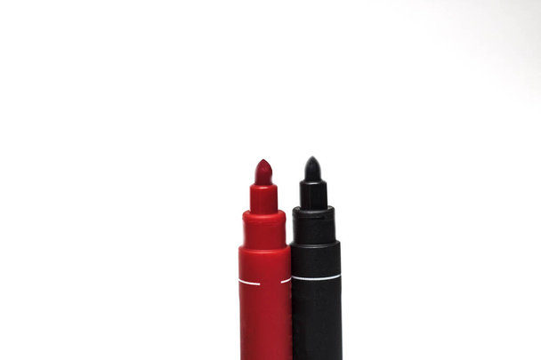 Marcadores vermelhos e pretos sobre fundo branco, isolados, canetas
 - Foto, Imagem