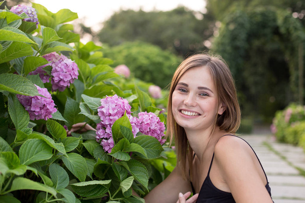 Portret van een meisje in de tuin, lachend portret, mooi portret van een meisje - Foto, afbeelding