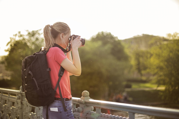 Young blonde woman taking a picture with a camera outdoor. - Foto, Imagem