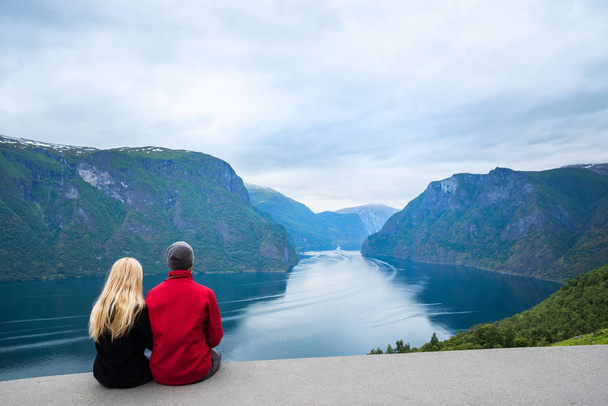 Панорама Согне-фьорда. Туристическая пара наслаждается прекрасным видом на фьорд и горы
 - Фото, изображение