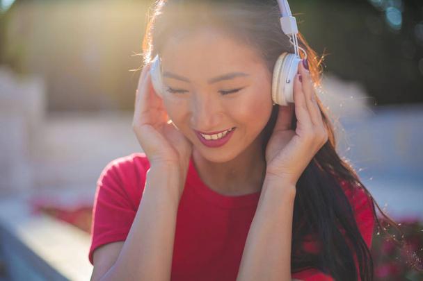 Beautiful Asian woman with headphone listening to music. - Valokuva, kuva