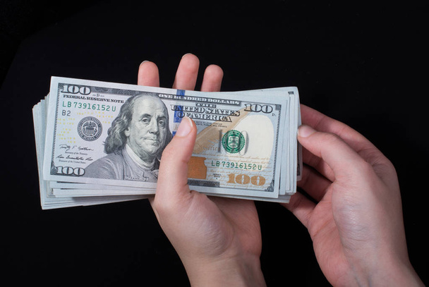 Hand-holding Amerikaanse dollar bankbiljetten geïsoleerd op witte achtergrond - Foto, afbeelding