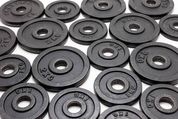 Black metal weights 1kg and 2kg on white background. - Photo, Image