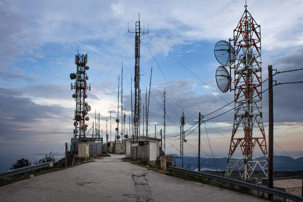 Aantal netwerk toren staan hoog in de buurt van de klif naast een zandstrand. Tientallen draad aangesloten op elke transmissie te geven van de levering van elektriciteit in die landelijk gebied - Foto, afbeelding