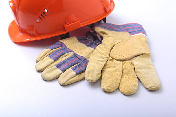 Orange hard hat, goggles and safety gloves on a white background. - Foto, afbeelding