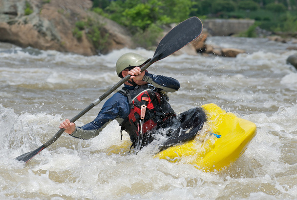 kayaker vechten de stroomversnellingen van een rivier. - Foto, afbeelding