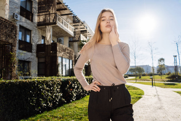stylish young blond model girl in fashionable clothes posing outdoors in the sun - Zdjęcie, obraz
