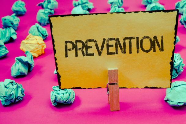 Escritura manual conceptual mostrando Prevención. Exhibición de fotos de negocios Impedir que algo suceda Protección de la salud Mantenga la retención de pinza de ropa Ideas de papel amarillo papel arrugado fondo rosa
 - Foto, imagen