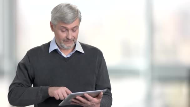 Hombre guapo usando tableta digital sobre fondo borroso
. - Metraje, vídeo