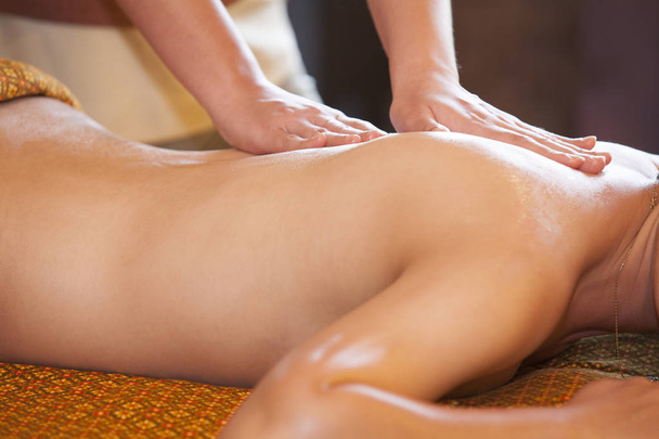 woman receiving back massage at spa. Female having relaxing massage on her back in spa salon. - Photo, Image