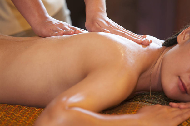 vrouw ontvangen rugmassage in spa. Vrouw met ontspannende massage op haar rug in spa salon. - Foto, afbeelding