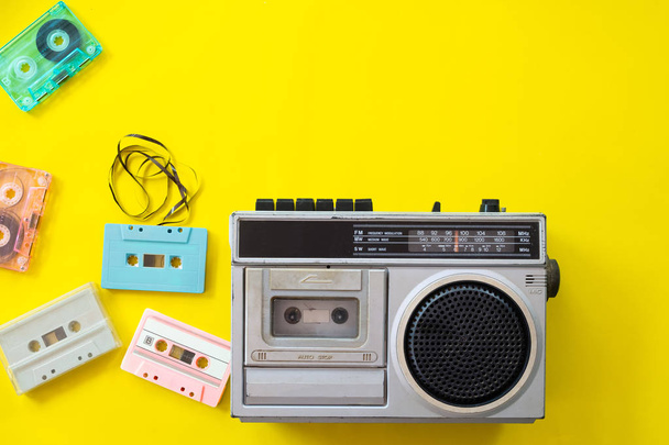 Vintage Radio und Kassettenspieler auf gelbem Hintergrund, flach gelegt, Draufsicht. Retro-Technik - Foto, Bild