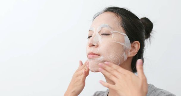 Mulher aplicar máscara de papel cuidados com a pele
 - Foto, Imagem