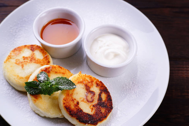 Cottage cheese pancakes with honey and sour cream - Foto, immagini