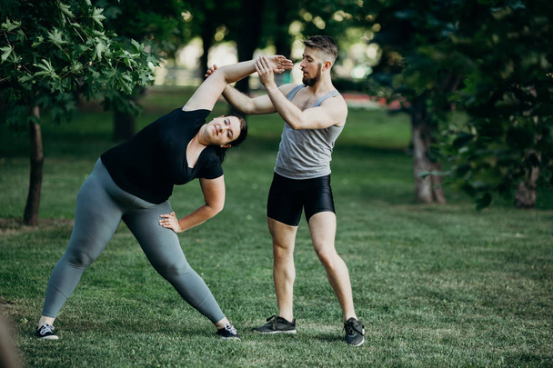 Fat woman doing yoga with fitness instructor - Foto, immagini