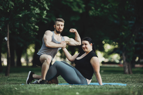 Muscular man and obese woman at street workout - Valokuva, kuva