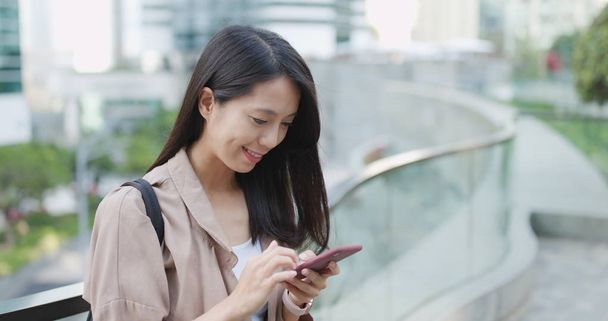 Mujer asiática enviando sms en el teléfono celular
 - Foto, imagen