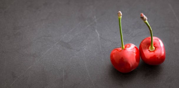macro de cereza fresca en un concepto de fondo negro de la nutrición saludable y vitaminas
 - Foto, imagen
