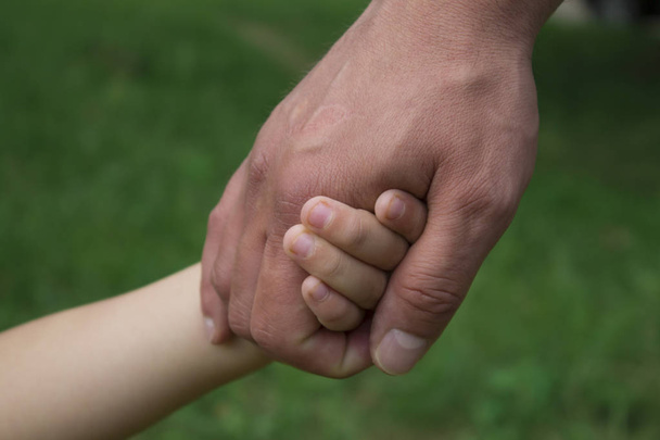 otec drží svého synka za ruku - Fotografie, Obrázek