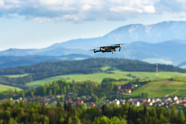 Drone avec caméra survolant les champs de montagne. Photographie aérienne et vidéographie. Copter drone quad avec appareil photo numérique haute résolution en l'air
 - Photo, image