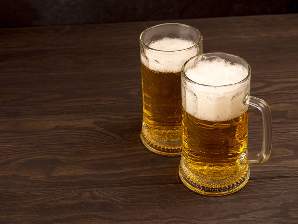 Два стакана пива на старых деревянных досках, копирайт для текста
. - Фото, изображение