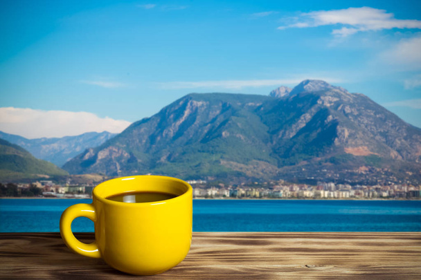 Tasse jaune avec thé sur une table en bois face à un fond déconcentré. Collage. Concentration sélective. tonique
. - Photo, image