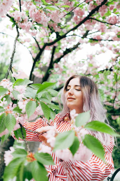 Napos Park, Cherry Blossom szezonban élvezi a gyönyörű fiatal nő - Fotó, kép