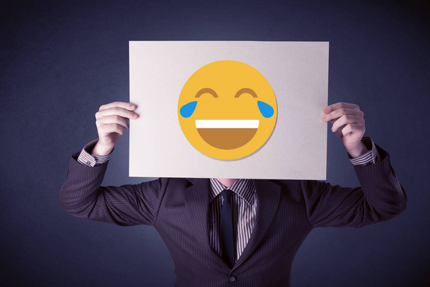 Businessman holding paper with laughing emoticon - Foto, imagen