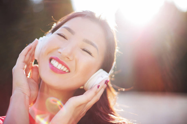 Beautiful Asian woman with headphones listening to music happily. - Foto, immagini