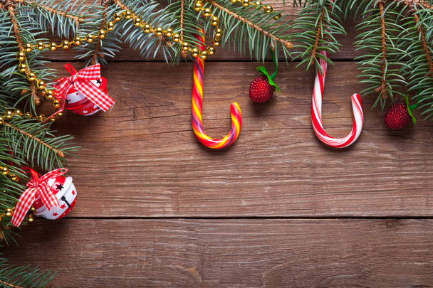 Branche d'arbre de Noël, canne à bonbons et éléments décoratifs sur une table ou une planche en bois pour l'arrière-plan. Thème du Nouvel An. Espace pour le texte
. - Photo, image