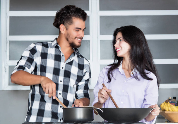 Beautiful young love couple cooking at home at modern kitchen - Fotoğraf, Görsel