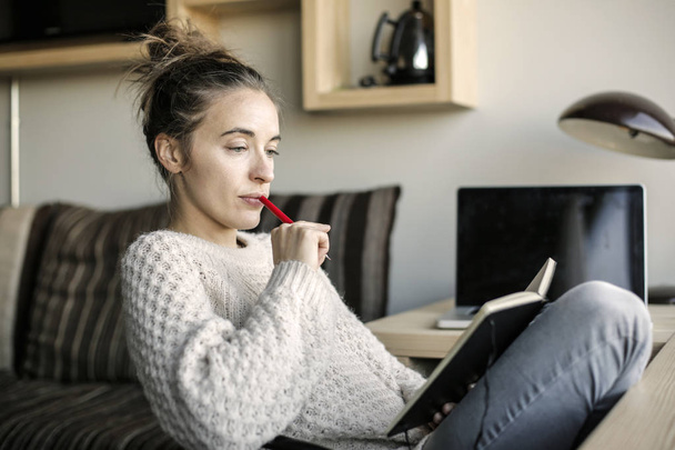 Young woman reading her agenda at home. - Φωτογραφία, εικόνα