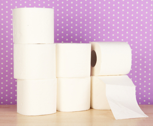 Rolls of toilet paper on purple with dots background - Foto, Imagen