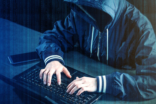 Anonyymi hakkeri ohjelmoija käyttää kannettavaa hakkeroida järjestelmään. Henkilötietojen varastaminen. Pahansuovan viruksen luominen ja tartuttaminen. Tietoverkkorikollisuuden ja hakkeroinnin käsite elektroniset laitteet
 - Valokuva, kuva