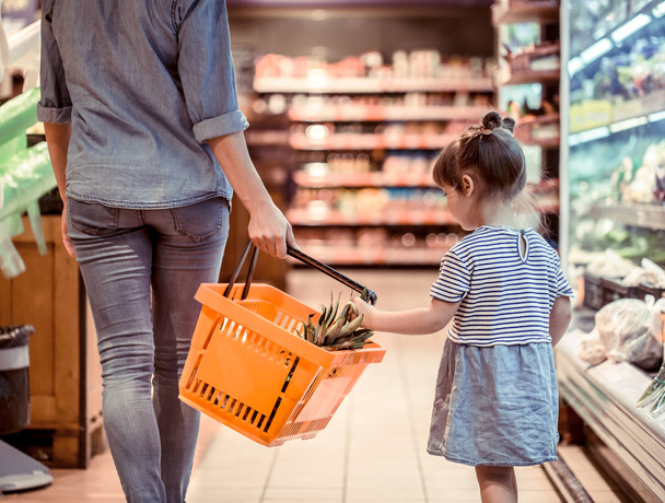 Mom and daughter are shopping at the supermarket, the concept of family relationships and healthy eating - Foto, Imagem