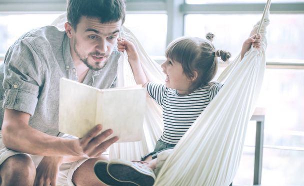 Apa és lánya, olvasni egy könyvet, egy kávézó, ünnepelni az Apák napja, családi értékek - Fotó, kép